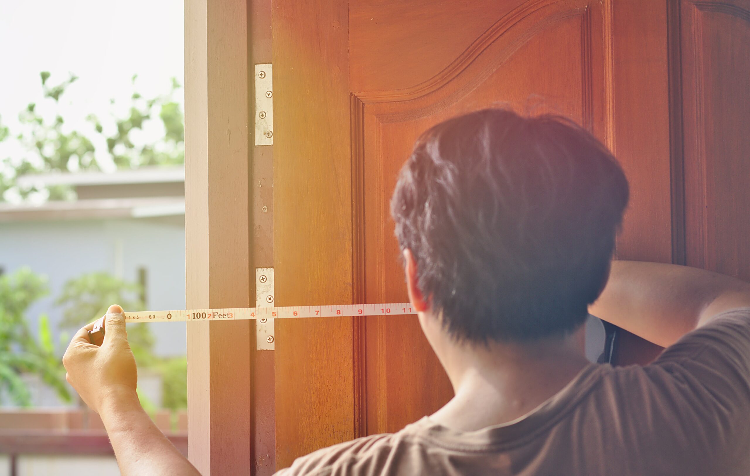 a man measuring a door