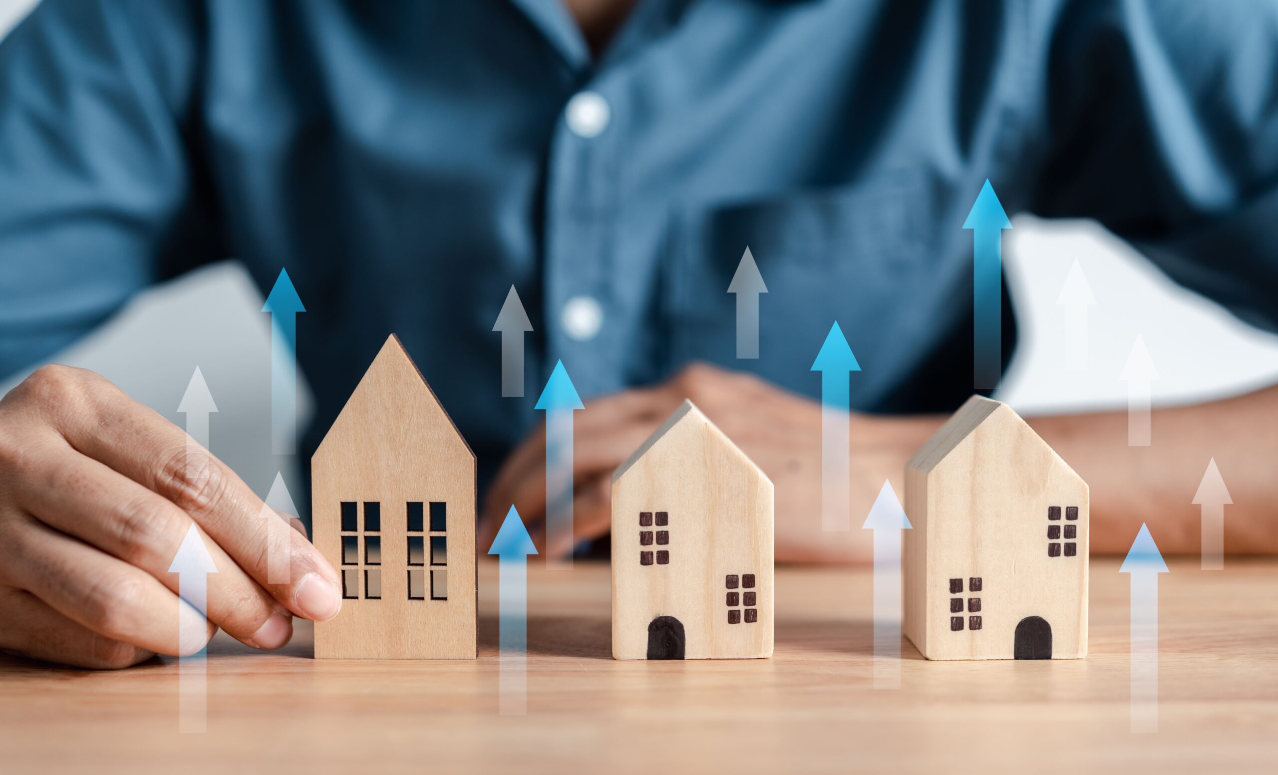 wooden house figures with blue arrows pointing upward