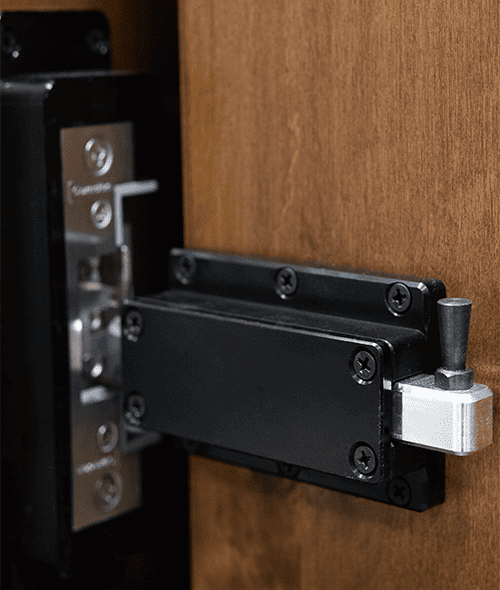 A close-up of the black and silver latch installed on the brown Shoe Rack Secret Door, with the bolt extended into a metal plate—ideal for securing your hidden storage.
