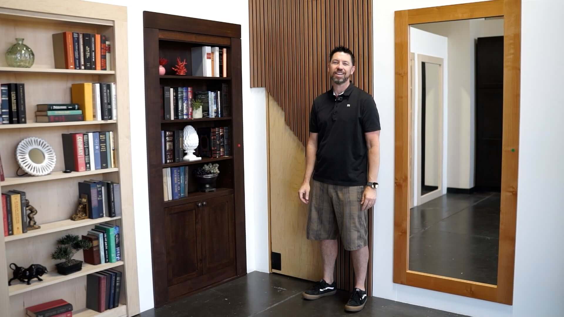 Steve Humble stands in front of secret bookcase door
