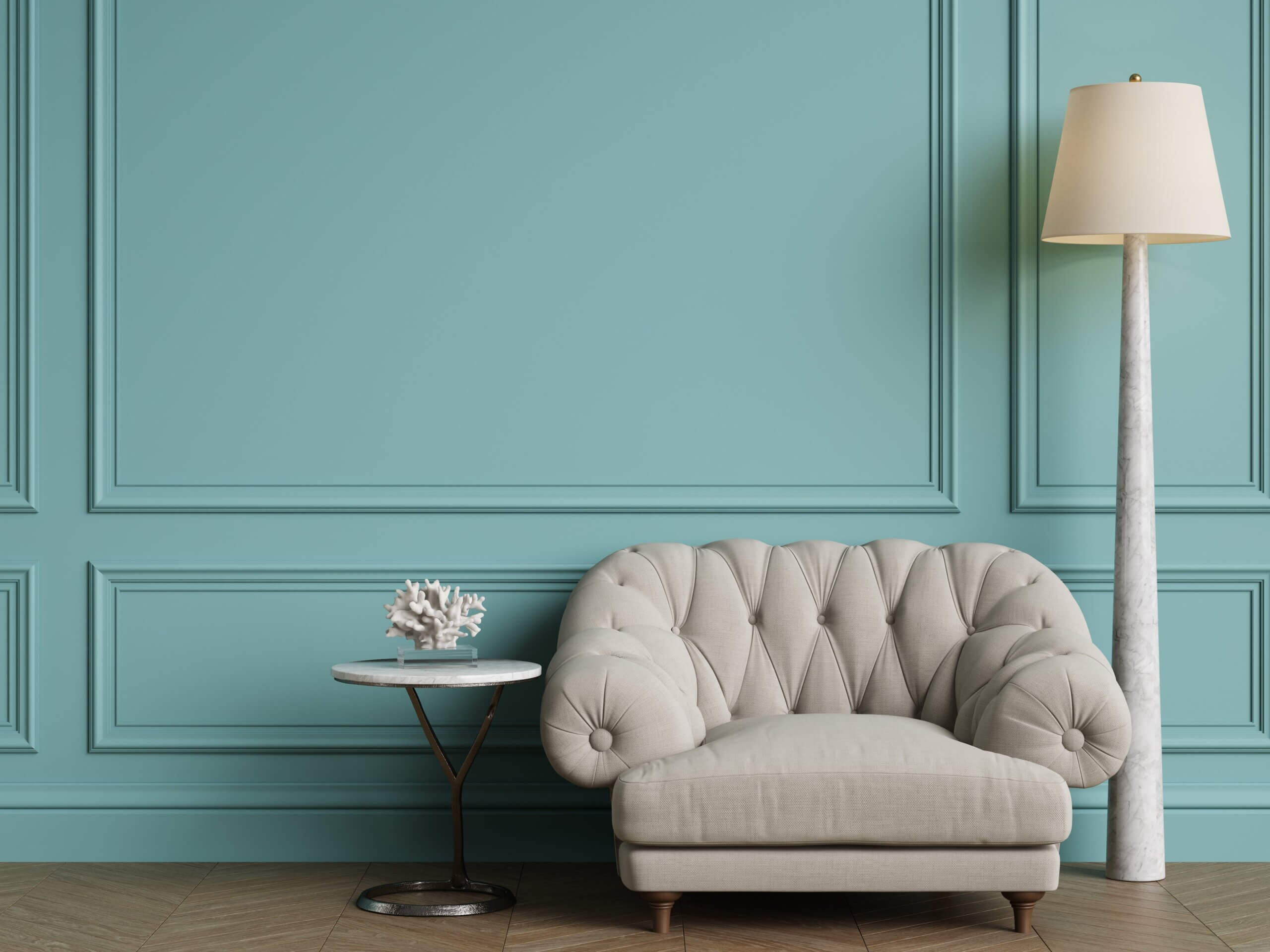 Elegant interior with a turquoise board and batten wall, tufted armchair, marble floor lamp, and round side table.