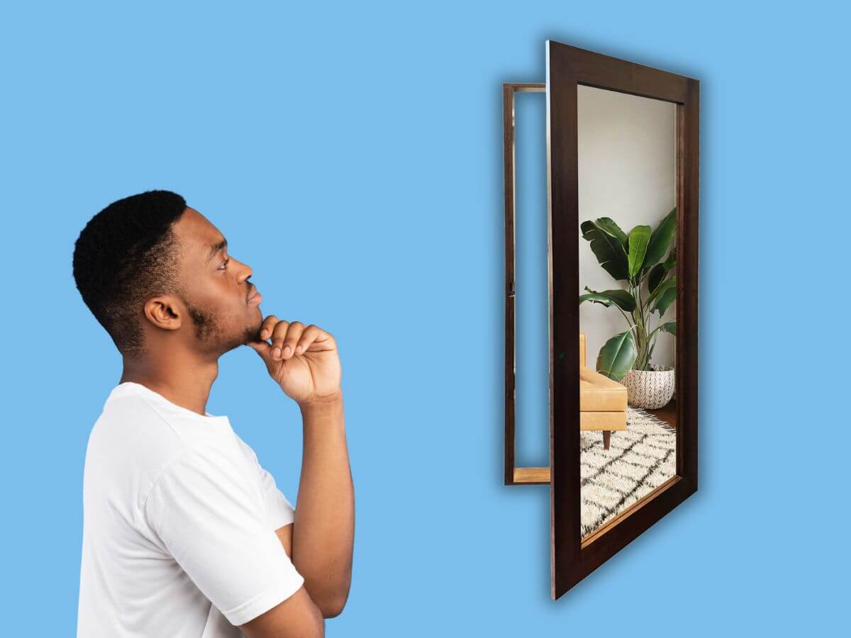 Man looking at a hidden mirror door that opens into a concealed room