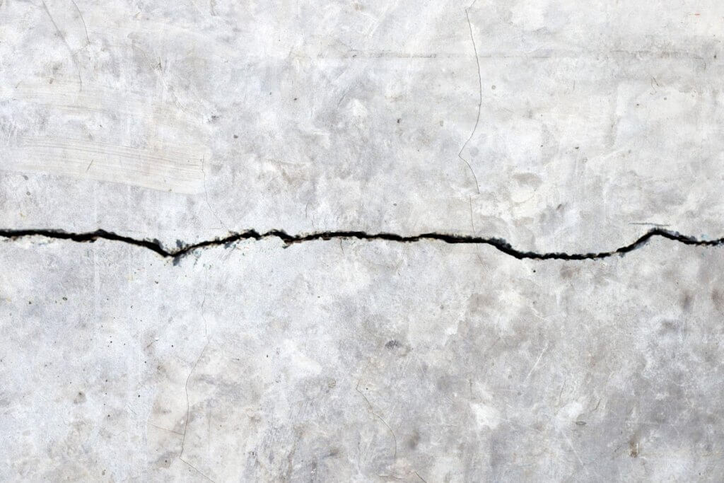 Large horizontal crack running through a concrete wall surface