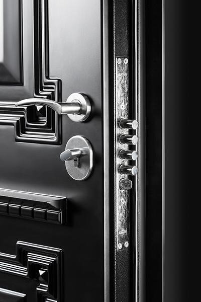 Close-up of a high-security black steel door featuring reinforced multi-point locking bolts, modern silver hardware, and heavy-duty security construction.